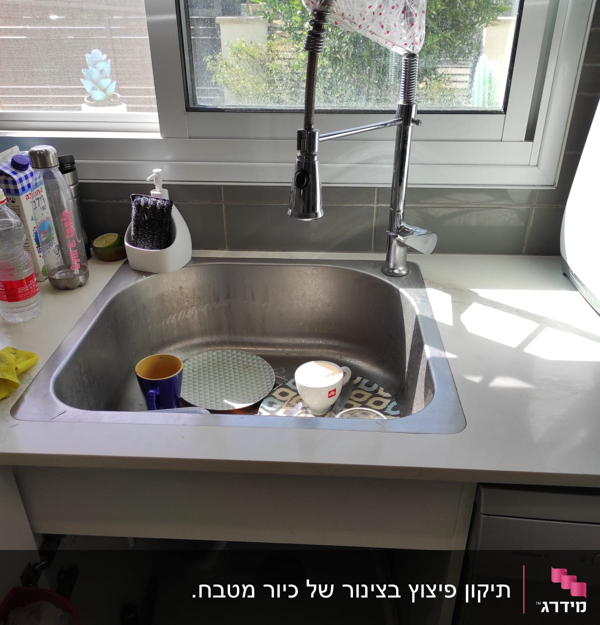 ברז מטבח עם צינור גמיש מעל כיור נירוסטה